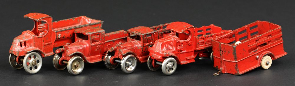 LOT OF FOUR TRUCKS: Cast iron grouping, includes two small red stake trucks by Arcade & A.C. Williams, one red pick-up truck by Arcade, larger stake truck in red by Dent Hardware, all have nickel wheels; also stake side 