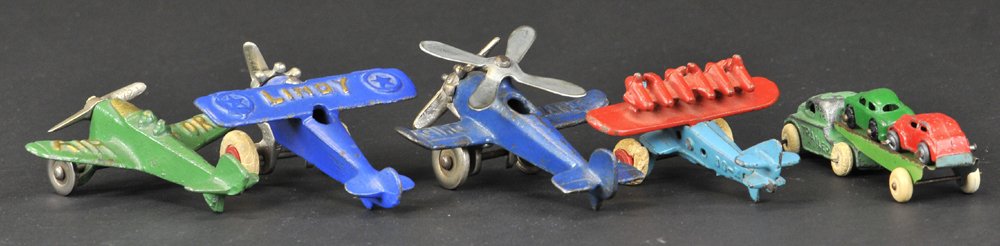 GROUPING OF SMALL AIRPLANES & TRAILER TRUCK: Hubley, cast iron, includes: Lindy in blue, DO-X in blue and red, Gyro Plane in blue with nickel prop, and Air Ford in green, together with small trailer truck and two cars on carrier. 3 1/2" wingspan