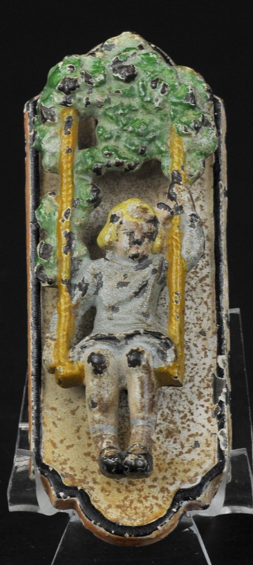 GIRL ON SWING DOOR KNOCKER: Hubley, extremely rare, charming doorknocker depicts girl swinging on rope swing which hangs from tree, beautiful casting. 3 1/2" h.