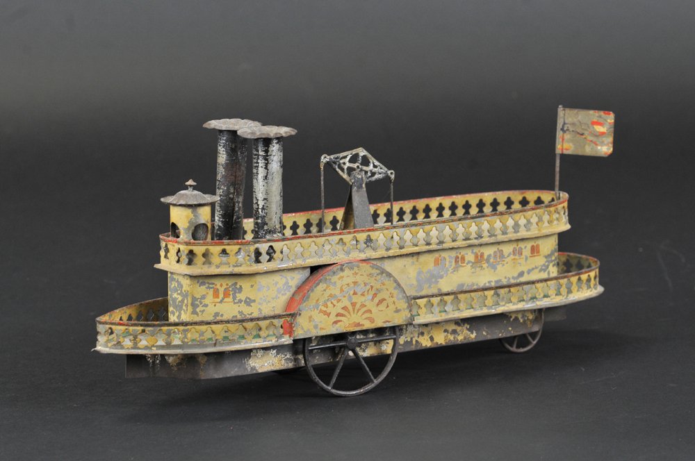 ALTHOF BERGMANN "PACIFIC" FERRY BOAT: Hand painted Early American tin toy, done in white overall with stenciling, features two stacks, reads "Pacific" on side wheel, cast iron spoke wheels, ornate railing on both levels. 13" l.