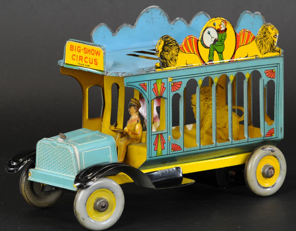 FERDINAND STRAUSS 'BIG SHOW' CIRCUS WAGON: Lithographed tin, great visual toy, cage wagon contains lion and tamer, marquee die-cuts depict circus theme, seated driver, great action, clockwork driven. 10 3/4" l.