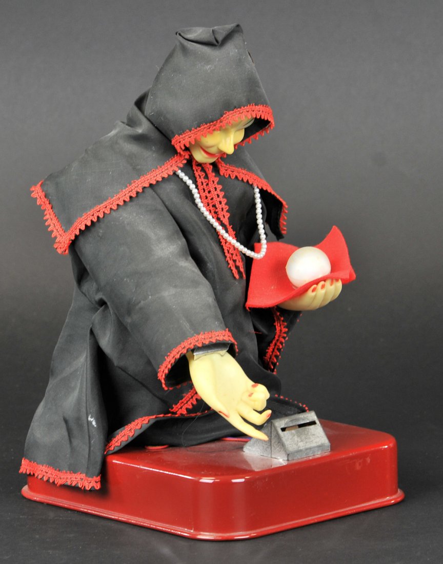 'GYPSY FORTUNE TELLER' TOY BANK: Vintage Ichida Japan tin toy, very rare. Place a coin in the slot and she will nod her head and raise her right hand as her left hand with the crystal ball moves. Her eyes flash three times and she lo