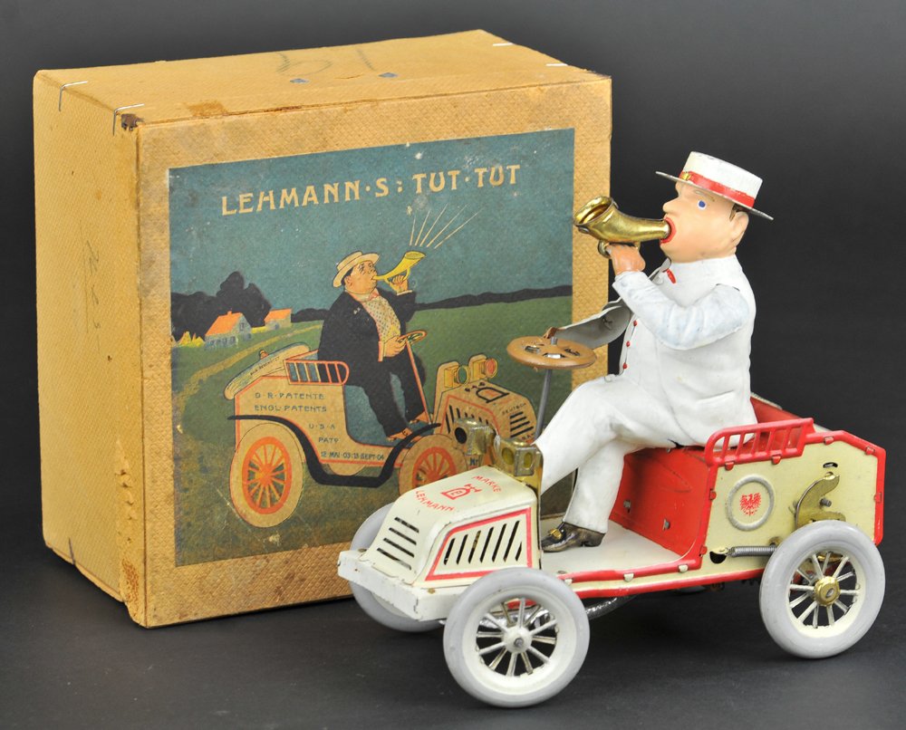 LEHMANN TUT TUT WITH BOX: Germany, a classic toy depicts suited gentleman riding open auto while blowing a horn, done in lithographed tin, very detailed example, clockwork driven, bellows are working. 6 3/4'' long.