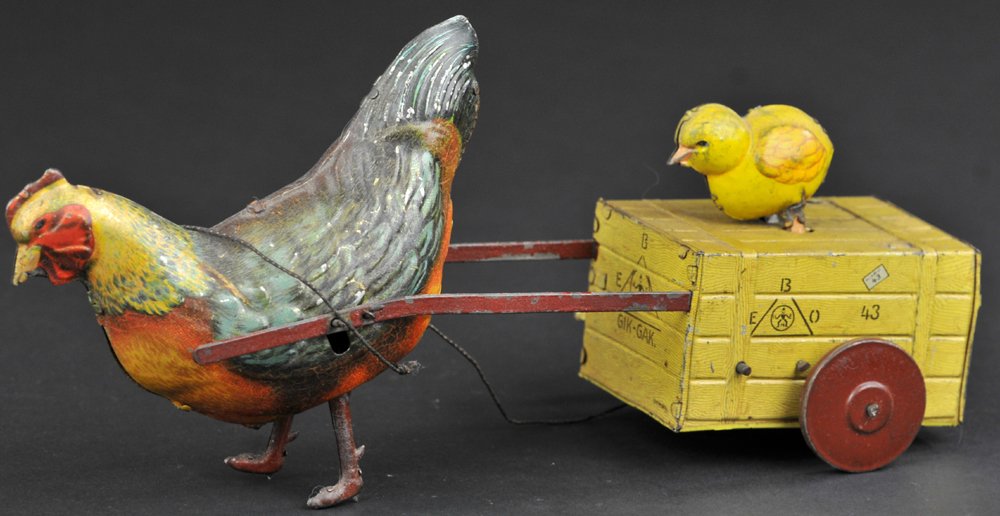 GIK-GAK HEN PULLING CHICK: Eberl, Germany, lithographed tin, brightly colored rooster pulls chick on simulated wooden crate, EBO logo stamped on all four sides, chick squeaks when rolling, key wind mechanism. 9" l.