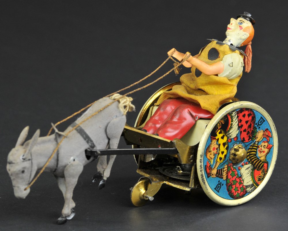 LEHMANN BALKY MULE: Germany, a signature toy for the company, lithographed tin, amusing clown figure rides comical cart, colorful wheels with strong graphic images, clockwork driven. 7 1/4'' long.
