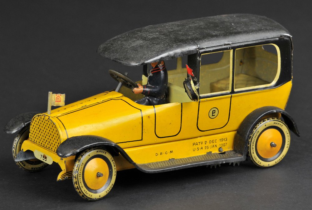LEHMANN TAXI: Germany, c. 1930's, lithographed tin, yellow body, black roof and running boards, features hood flag, and taxi meter on side, seated driver, clockwork driven. 7'' long.