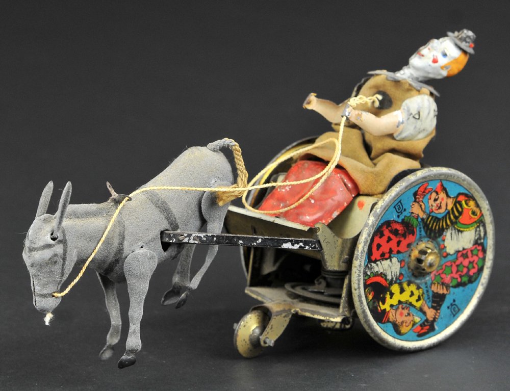 LEHMANN BALKY MULE: Germany, a signature toy for the company, lithographed tin, amusing clown figure rides comical cart, colorful wheels with strong graphic images, clockwork driven. 7 1/4'' long.