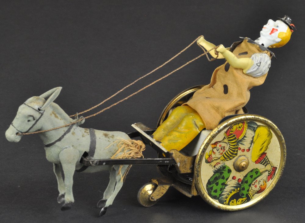 LEHMANN BALKY MULE: Germany, a signature toy for the company, lithographed tin, amusing clown figure rides comical cart, colorful wheels with strong graphic images, clockwork driven. 7 1/4'' long.