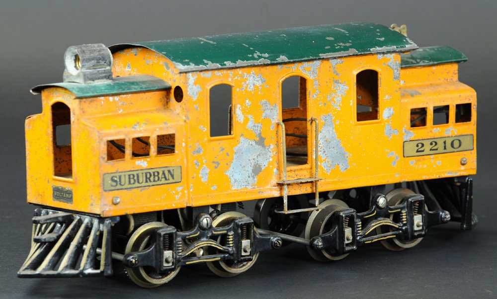 VOLTAMP NO. 2210 SUBURBAN ENGINE: Circa 1918-1920, rare color example done in orange body and green roof, bell on roof, paint flaking and pitting decals intact, all original. 15" l.