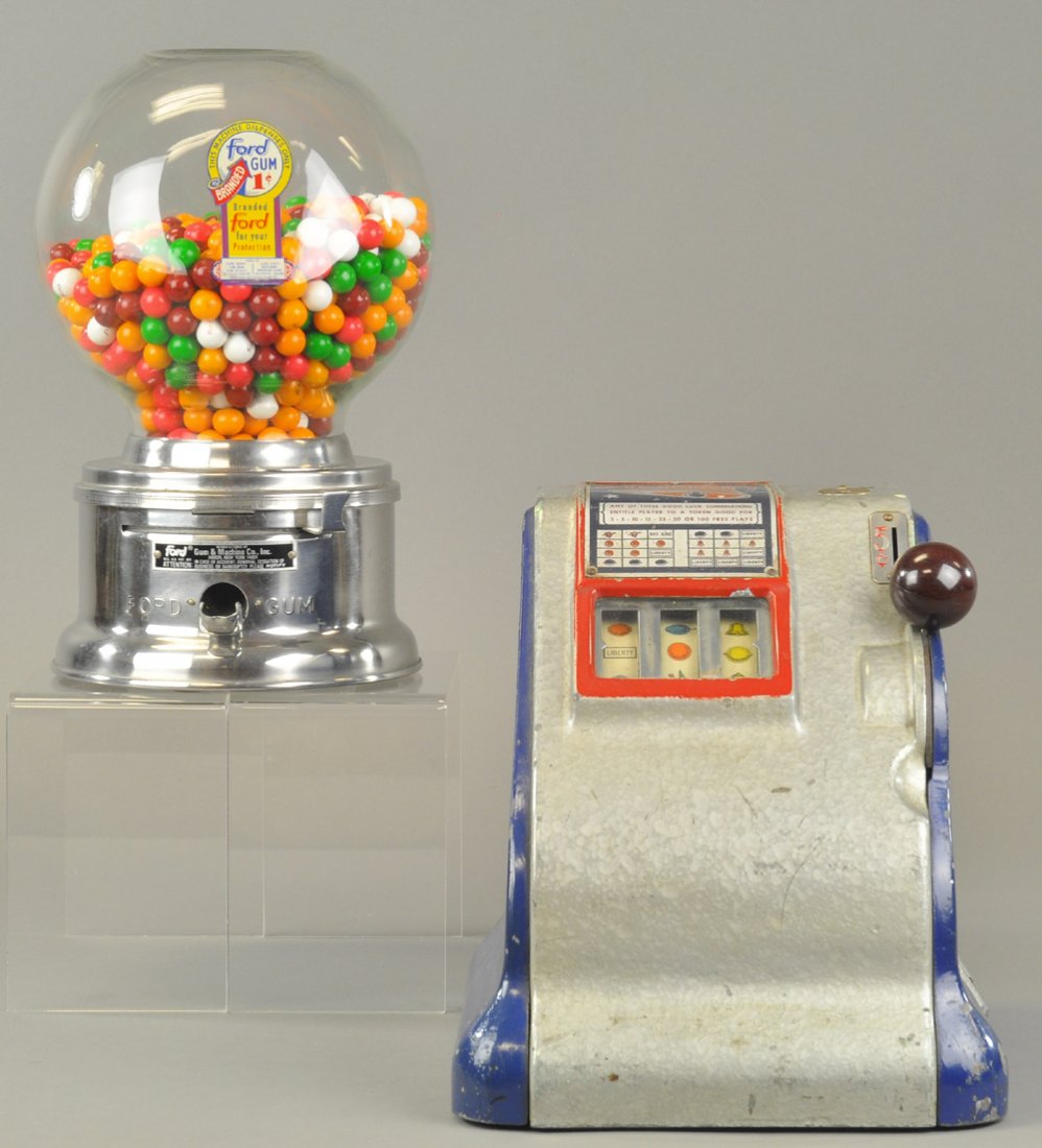 LOT OF TWO AMUSEMENT MACHINES: Includes spring loaded cast Liberty slot machine which took 5¢ coins and gave free play tokens according to symbol, and 1¢ gumball machine with "Ford Gum" decal on glass globe top. 10" to 12" h.