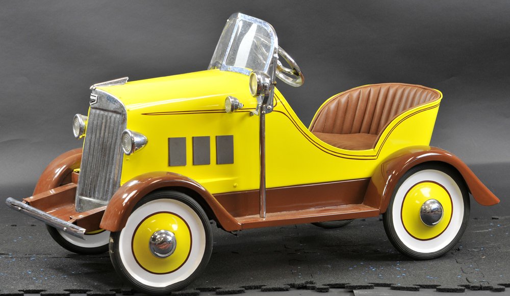 AUBURN PEDAL CAR: c. 1930's, pressed steel body, attractive color scheme painted in yellow and brown overall, extensive appointments include: headlamps, side lamps, searchlight on fender, windshield, hood ornament, rub