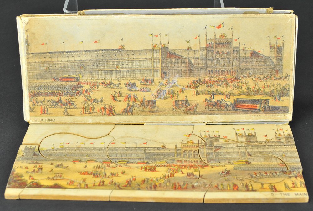 CENTENNIAL EXPOSITION PUZZLE: Scroll cut lithographed paper on wood puzzle pieces depicting main building of the 1879 exposition, features original box with graphic image of famed building and used as the puzzle guide sheet. 21" w