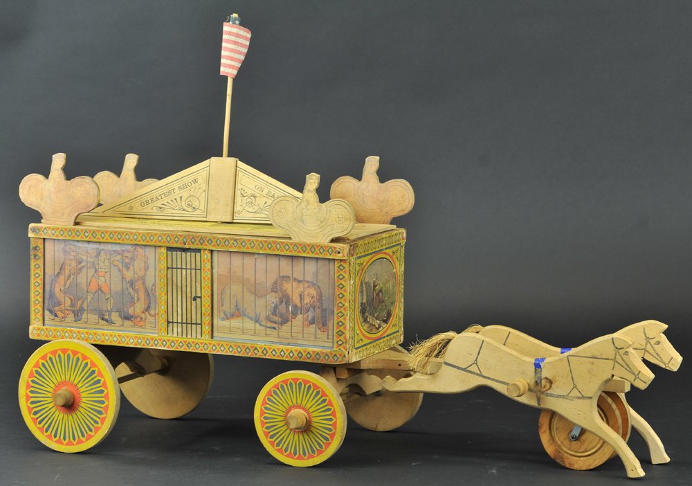 REED MENAGERIE WAGON: Lithographed paper on wood wagon with printed wood signboards and galloping horses, complete with four reversible full color images of animals in cages, very scarce circus toy. 26" l.