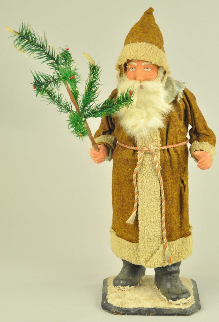 GERMAN SANTA CLAUS CANDY CONTAINER: Santa wearing a brown felt robe and hood trimmed in white, rabbit fur beard on a composition head, very nice feather tree in one hand. 17" h. Ex. Tom Fox Collection.