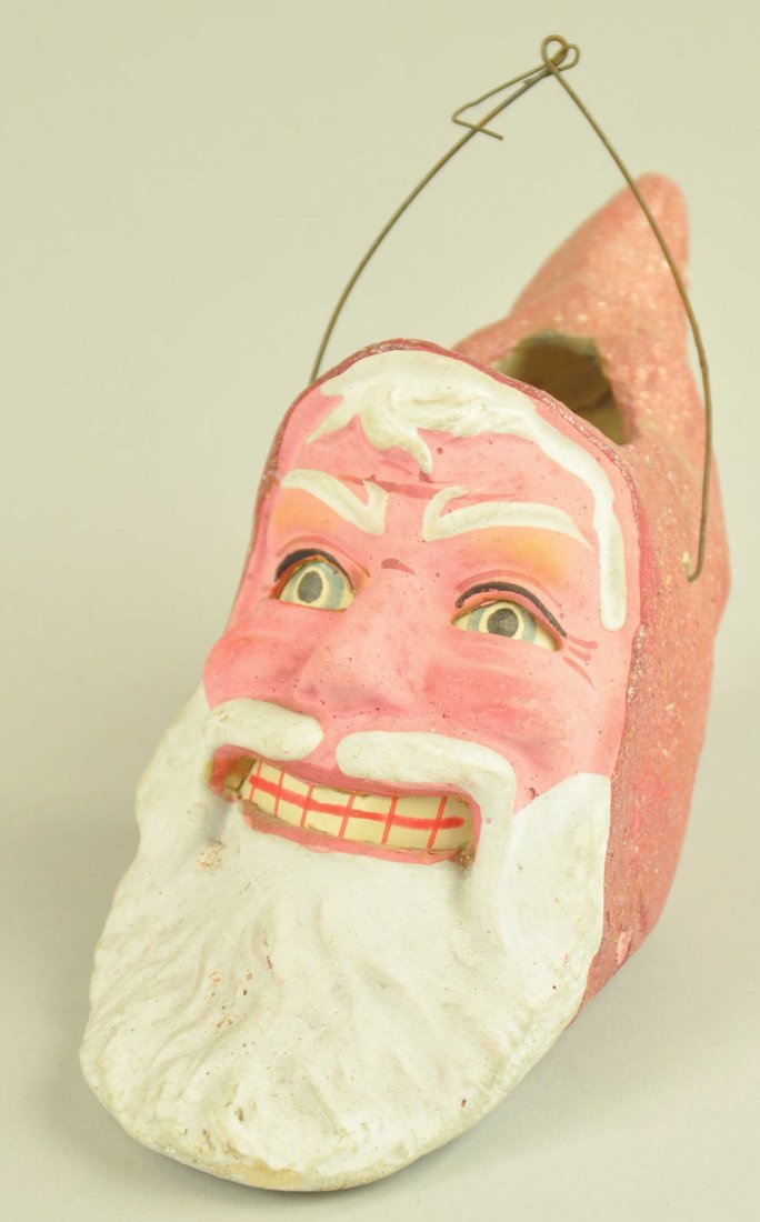 BAIL HANDLE SANTA LANTERN: Germany, hand decorated composition red hood smiling Santa lantern, complete with paper inserts of eyes and mouth. 7 1/2" h. Ex. Tom Fox Collection.