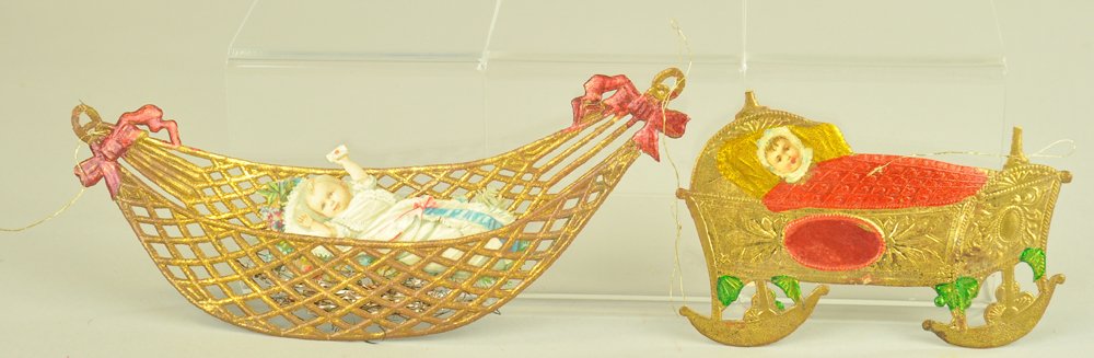TWO FLAT GERMAN DRESDEN BABY ORNAMENTS: Germany, embossed and die-cut baby in hammock, along with a baby in cradle Christmas tree ornaments. 3" to 7" l. Ex. Tom Fox Collection.