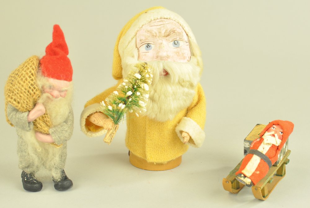 THREE CHRISTMAS FIGURALS: Lot includes a composition Santa squeaker toy with yellow coat, composition Santa on sled with Dresden "Merry Christmas" candy box, and a mischievous looking elf made of composition & cloth. 3 1/2" to