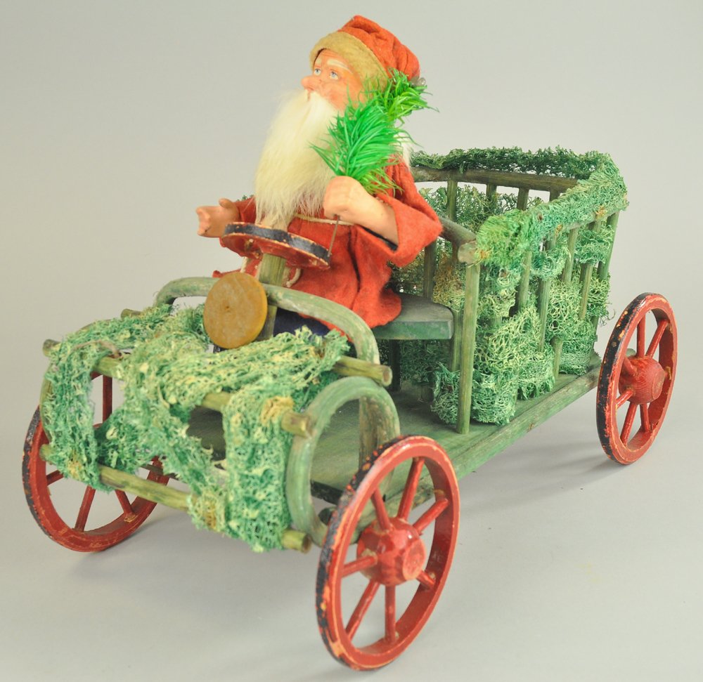 LARGE LICHEN MOSS & SANTA AUTO: Germany, lichen moss and green sticks auto with Santa at the wheel, wearing blue pants and red felt top, composition head with rabbit fur beard, composition hands with feather tree sprig, large space 