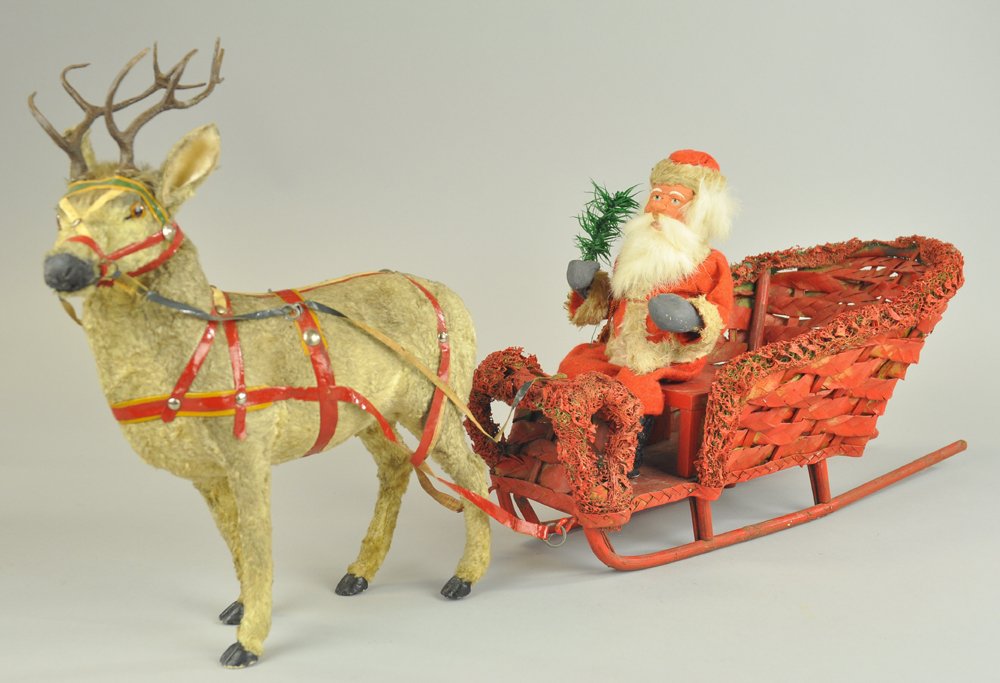 SANTA RIDING SLEIGH PULLED BY REINDEER: Well detailed braided wicker sleigh with lichen moss trim, pulled by felt covered reindeer, seated Santa with painted composition head, hands & boots, great size & details. 25" l.