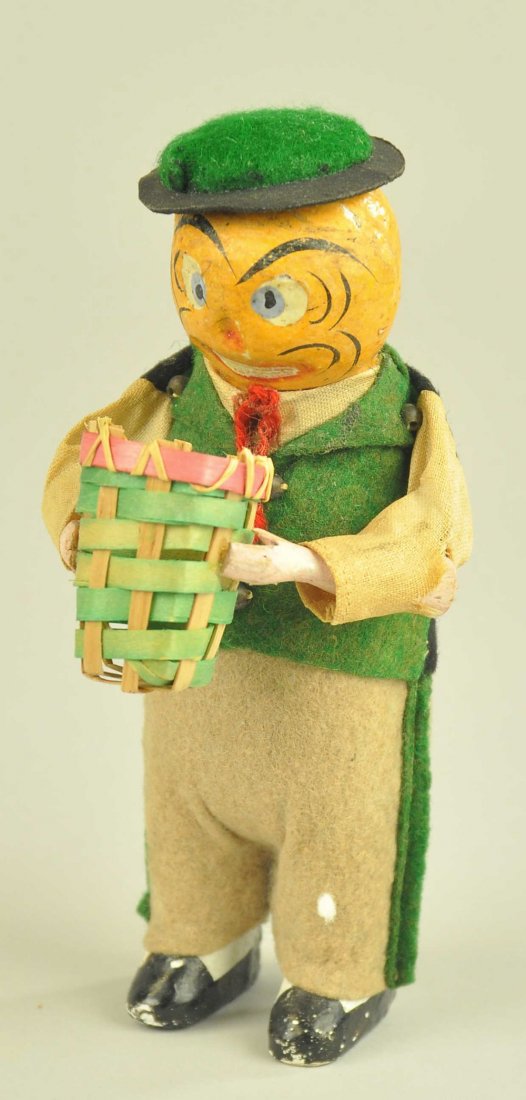 MECHANICAL JACK-O-LANTERN WALKING MAN: German mechanical wind-up Jack-O-Lantern man holding small wicker basket, superb color and condition, composition face, wooden arms, working, feet move around and arms move up & down. 6" h.