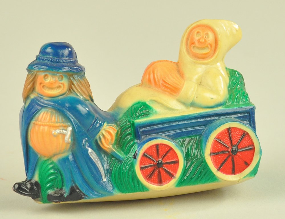 VISCALOID HALLOWEEN SCARECROW PULLING GHOUL IN CAR: Super scarecrow pumpkin man pulling ghost in cart with Celluloid-Viscaloid USA mark; this image also used by Dennison Co. in their paper decorations, no flaws noted. 3" l. Ex. Tom Fox Collection.