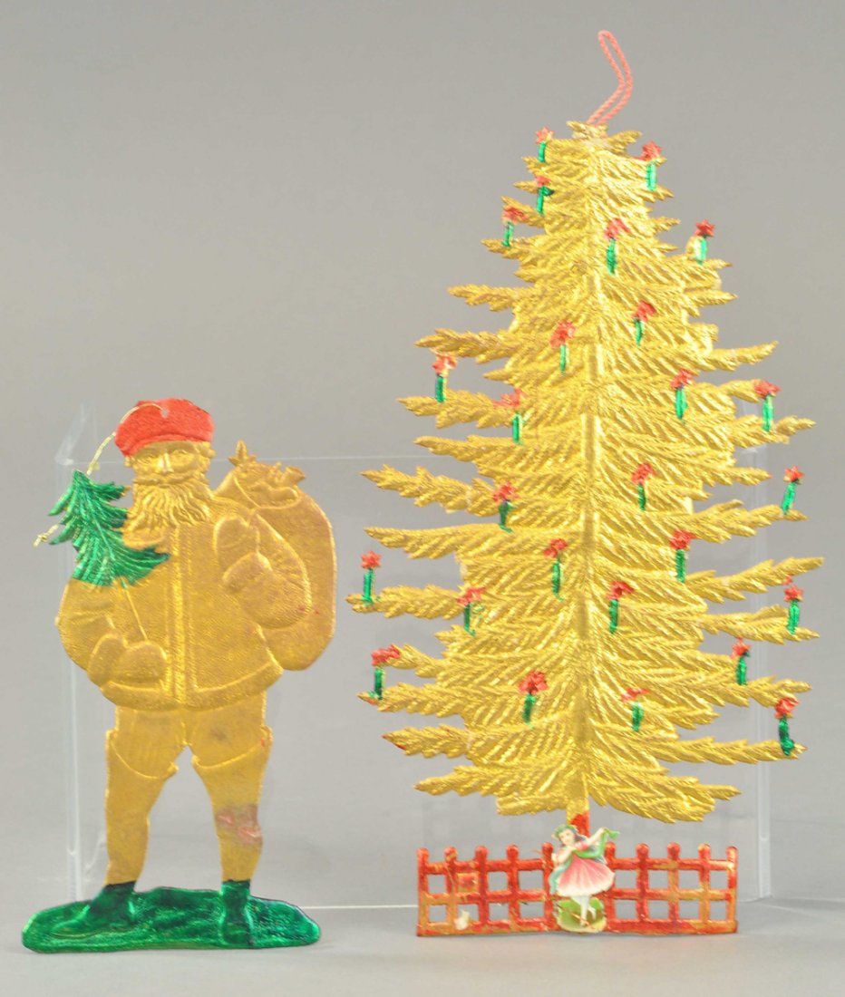 SANTA AND CHRISTMAS TREE FLAT DRESDENS: An embossed golden Christmas tree with burning candles along with Santa in red cap and toy sack on his back, holding small tree. 4 1/2" to 7" l. Ex. Tom Fox Collection.