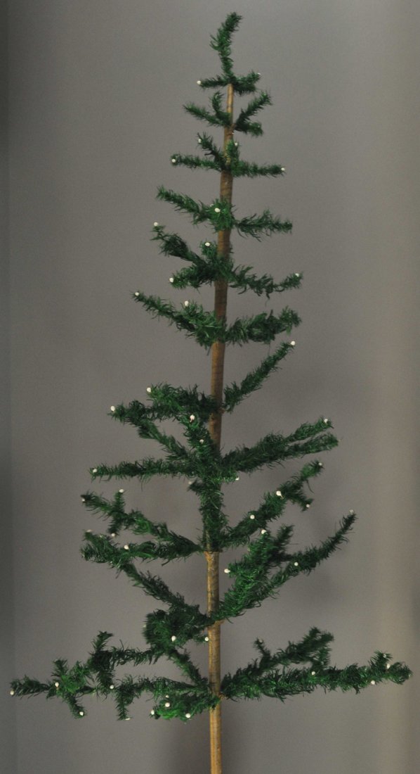 TALL FEATHER TREE: Five foot bold dark green German feather tree, red color has worn off berries, one branch is missing, some paper dislodged, base is missing. 60" h. Ex. Tom Fox Collection.