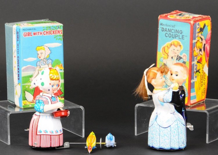 TWO JAPANESE WIND-UP TOYS: TPS, Japan, both boxed, includes Girl with Chickens and Dancing Couple, lithographed tin examples with wind-up action, couple have rubber heads. 5 1/4" h.