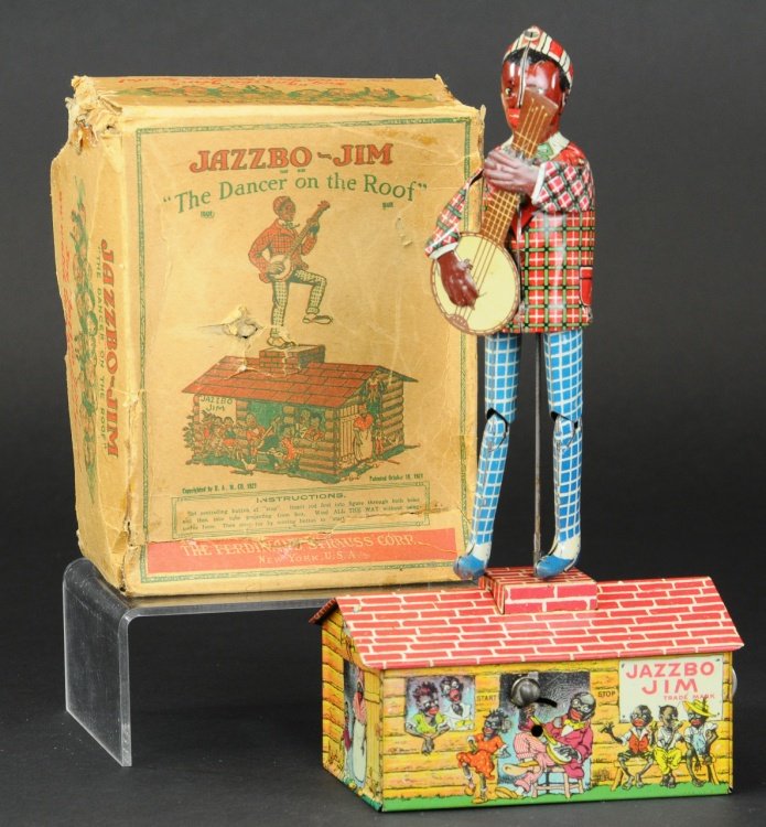 JAZZBO JIM WITH ORIGINAL BOX: Ferdinand Strauss Corp., lithographed tin wind-up, colorful graphics surround log cabin used as stage for Jazzbo Jim with banjo in hand, billed as the dancer on the roof. 10 1/4" h.