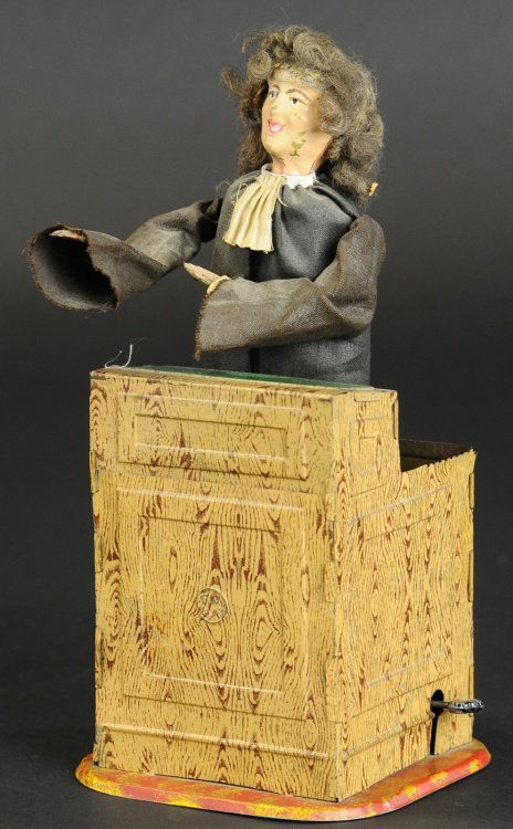 THE ADVOCATE: Fernand Martin, France, lithographed tin podium with standing figure, hand painted tin head, wears cloth suit, when clockwork is activated figure begins to raise arms and turn body at anyone willing t