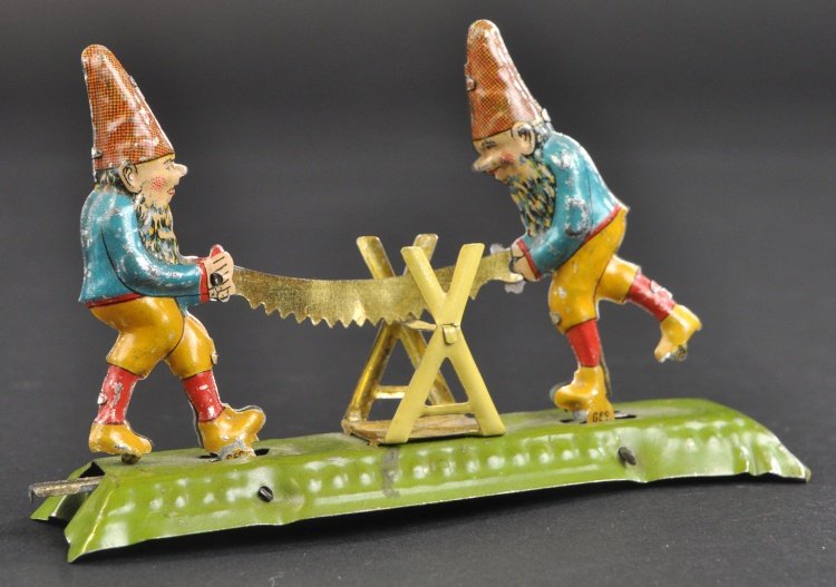 TWO GNOMES SAWING LOG PENNY TOY: Fischer, Germany, lithographed tin, whimsical and colorful, amusing depiction. 4 1/4" l.