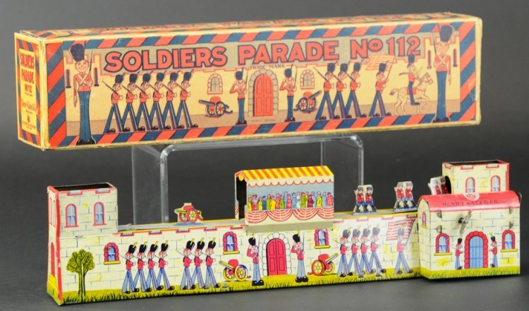 HENRY KATZ SOLDIERS' PARADE TOY: Boxed example, an elusive lithographed tin toy, wind up action allows belt drive to parade soldiers and cannons across rooftop. 16" l.