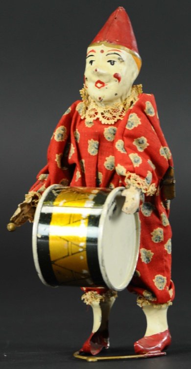 CLOWN PLAYING DRUM: Gunthermann, Germany, c. 1910, early tin toy depicts clown wearing cloth outfit playing bass drum, wind up action is quite amusing. 9 1/2" h.