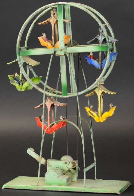 FERRIS WHEEL: Germany, Carette, hand painted in green overall, carnival ride toy features five varied colored gondolas, hand lever on base controls movement and musical sounds. 17 3/4" h.
