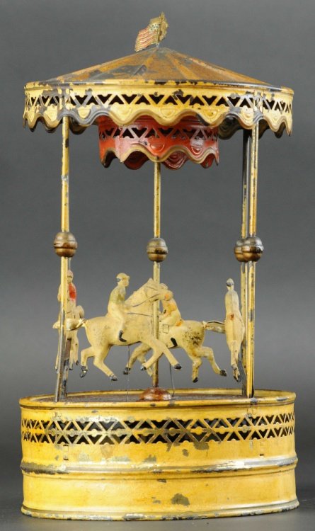 LARGE CAROUSEL: Germany, Gunthermann, c. 1910, hand painted tin, features four horses with riders at enter, canopy roof, clockwork driven. 17" h.