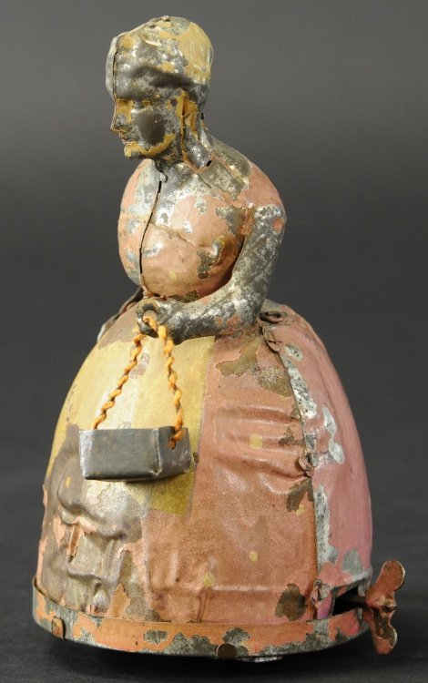 GUNTHERMANN LADY WITH UMBRELLA: Germany, toy was originally known as Aunt Jemima, hand painted tin, depicts lady holding umbrella and tin basket, clockwork driven. 6 1/2" h.