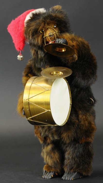 MECHANICAL BEAR WITH DRUM: A later example, well detailed overall with fur covering, glass eyes, wooden paws and feet, clockwork mechanism allows head to move back and forth while opening and closing his mouth as he bangs on dr