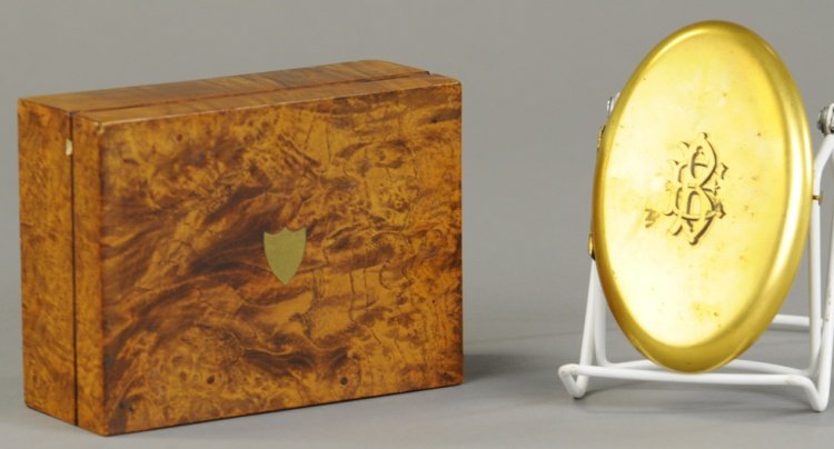 TWO SEWING CASES: Smaller- brass oval compact style set, containing scissors thimble, needle case and other sewing tools. Larger- in maple box with mirror, red leather interior with scissors and tools made primarily of