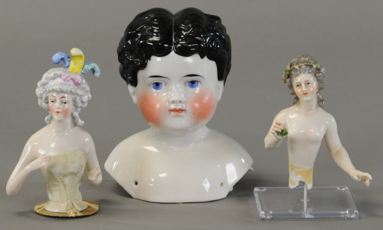 CHINA SHOULDER HEAD AND TWO PIN CUSHION DOLLS: c. 1890, molded curly black hair, painted blue eyes, pin cushion doll has Goebel mark inside body, grey hair and eyes, roses in hair; other doll has blue eyes, grey hair with feathers and bow in hair.