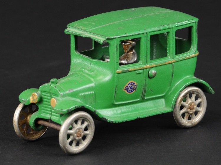 ARCADE FORD MODEL 'T' TUDOR SEDAN: C. late 1920's, cast iron, painted in green body, gold side striping, seated nickel driver, nickel spoke wheels. 6 1/2" l.