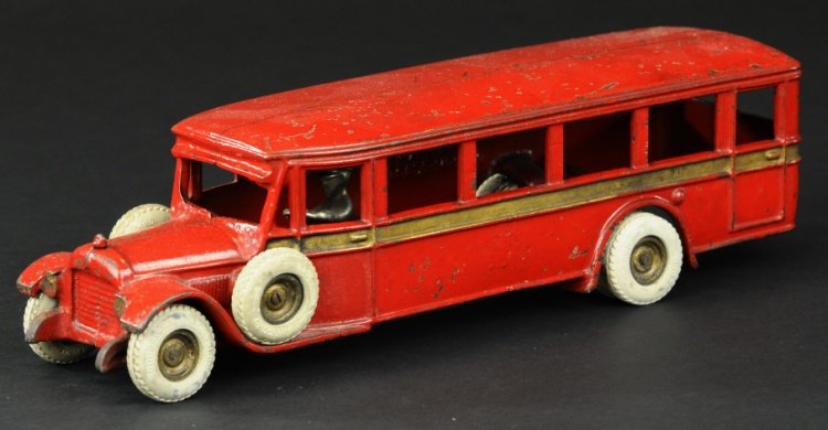ARCADE PARLOR COACH BUS: Late 1920's, large cast iron example, painted in red body, gold side stripe, seated nickel driver, rubber tires on cast iron hubs. 13" l.