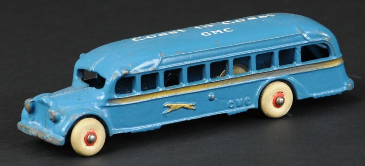 ARCADE GMC GREYHOUND BUS: Stenciled 'Coast to Coast GMC' on roof, cast iron body painted in blue, gold side striping, rubber tires. 7 1/2" l.