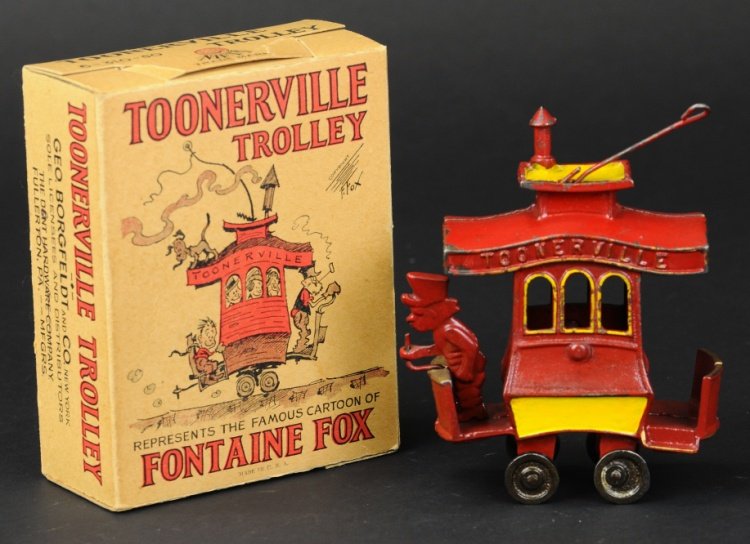 TOONERVILLE TROLLEY WITH ORIGINAL BOX: Cast iron, Mfg. by Dent, Fontaine Fox creation, painted in red with yellow side band and roof, standing conductor on front platform, with original Dent box. 5 3/4" l.