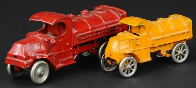 LOT OF TWO MACK FUEL AND OIL TRUCKS: Cast iron, includes an orange painted Hubley Mack tanker and a red Champion motor oil tank truck, both with nickel cast iron wheels. 5 3/4" - 8" l.