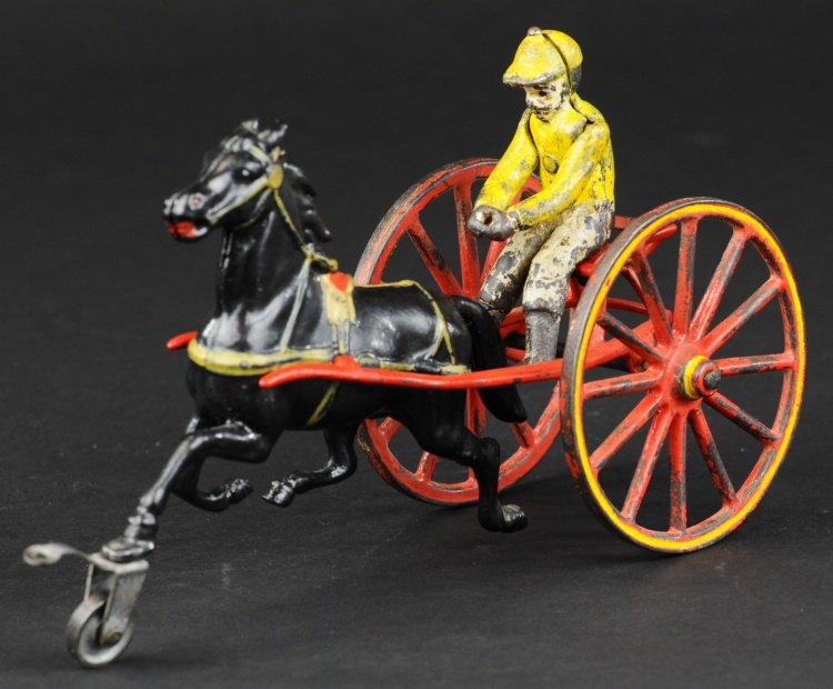 PRATT & LETCHWORTH SULKY: Cast iron, red sulky, embossed seating, large spoke wheels with gold trim, seated jockey, drawn by black horse. 8" l.