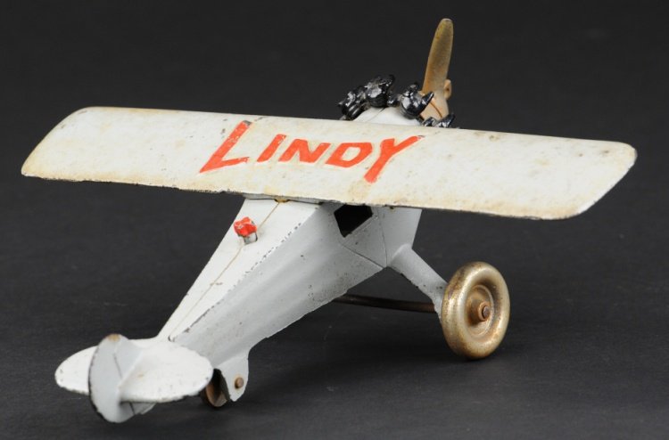 LINDY AIRPLANE: Hubley, c. late 1920's, cast iron classic toy airplane painted in grey with 'Lindy' embossed in red on wing, black motor, nickel propeller and disc wheels. 9" l.