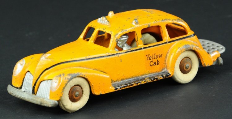 HUBLEY YELLOW CAB: C. 1940, cast iron, painted in bright orange color, decal on side reads 'Yellow Cab' on door, nickeled driver, white rubber tires, folding luggage rack on trunk. 8 1/4" l.