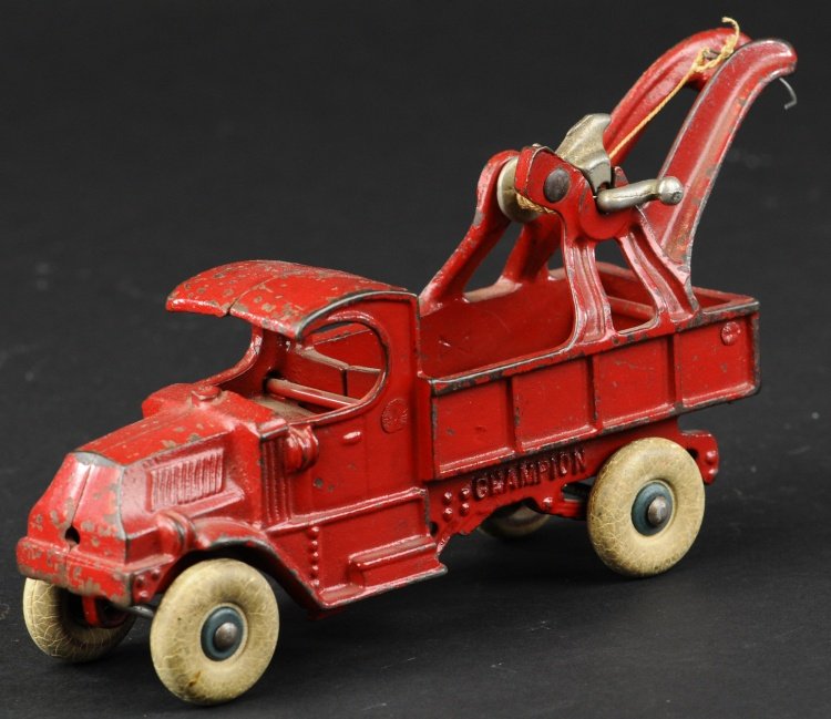 CHAMPION WRECKER: Cast iron, 'C' Mack cab painted in red overall, cast boom on open bed, nickel winch, white rubber tires. 7 3/4" l.