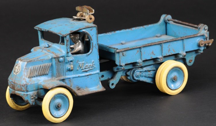 ARCADE MACK DUMP TRUCK: Cast iron, large size, painted in blue overall, body lifts for unloading with opening tailgate, disc wheels with rubber tires, seated driver, lever on side and 'T' bar pulley system behind cab. 12" l.