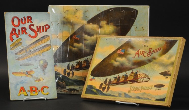 AIR SHIP BOXED PUZZLE AND ABC BOOK: Copr. 1904, McLoughlin Bros., scroll puzzle, lid has great graphic image of early dirigible with passengers, together with Ralph Tucker & Sons 'Our Air Ship,' child book with great cover graphics depi